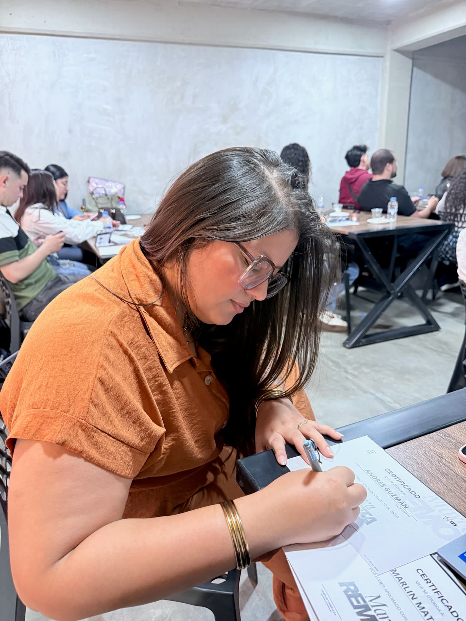 Anamar firmando certificados para participantes de un taller
